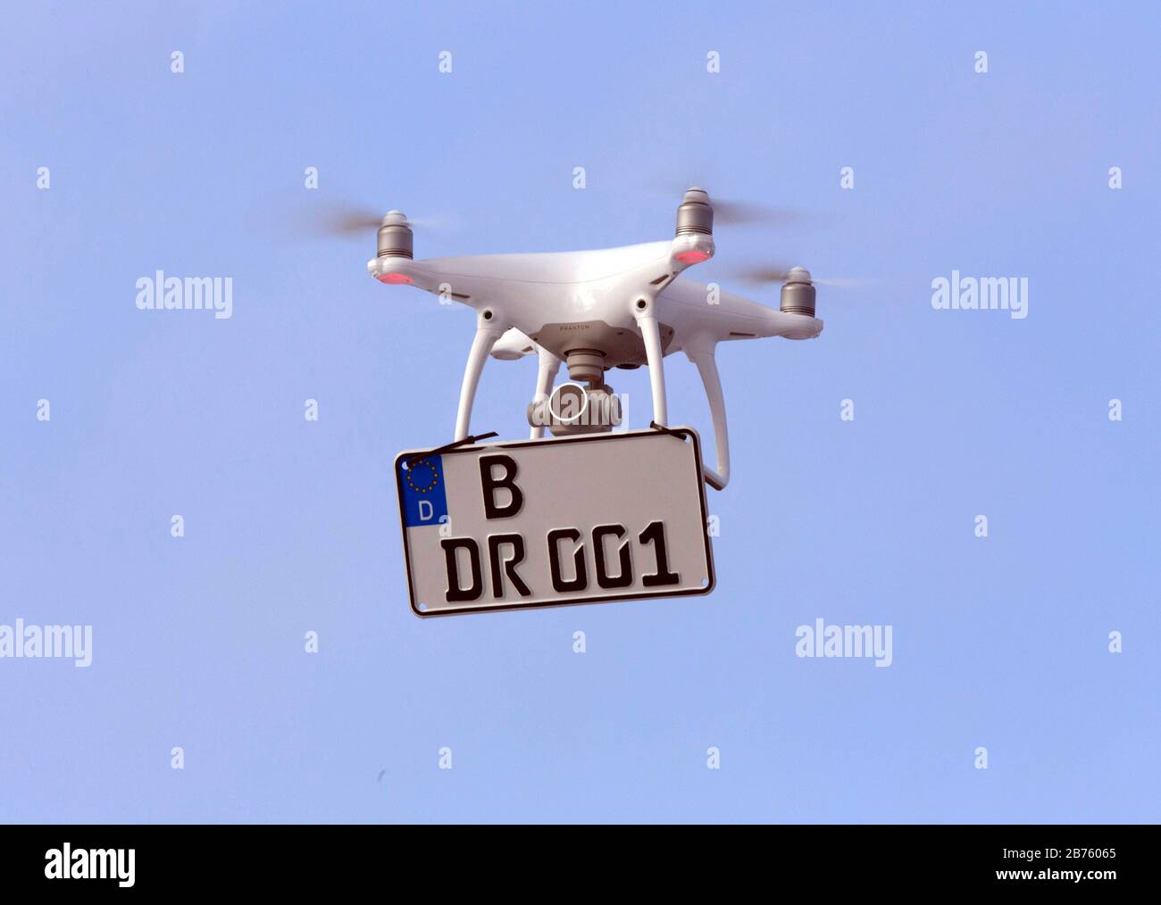 This is what a drone with mandatory marking could look like. A license plate number is attached to a flying drone on 22.01.2017. Every drone weighing more than 250 grams must in future be marked with a sticker. This way, in case of an accident, the owner can be quickly identified. The 'regulation for the regulation of the operation of unnamed aircraft', which has now been passed by the federal government, provides for flight bans for sensitive areas, labelling obligations and additional requirements for users. [automated translation] Stock Photo