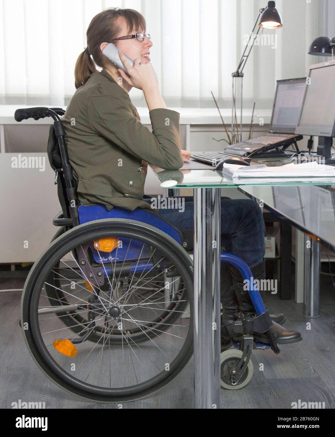 Young disabled woman in wheelchair on 18.01.2017 at her computer  workstation in an office. [automated translation] Stock Photo - Alamy