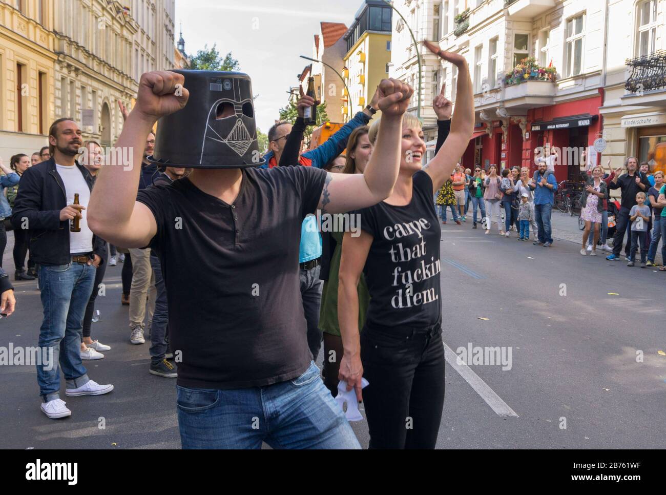 A supporter of the Berlin Marathon stands at the running course wearing a Darth Vader mask made of a bucket and loudly cheers on the runners with friends. 41,283 runners participated in the 43rd Berlin Marathon. [automated translation] Stock Photo