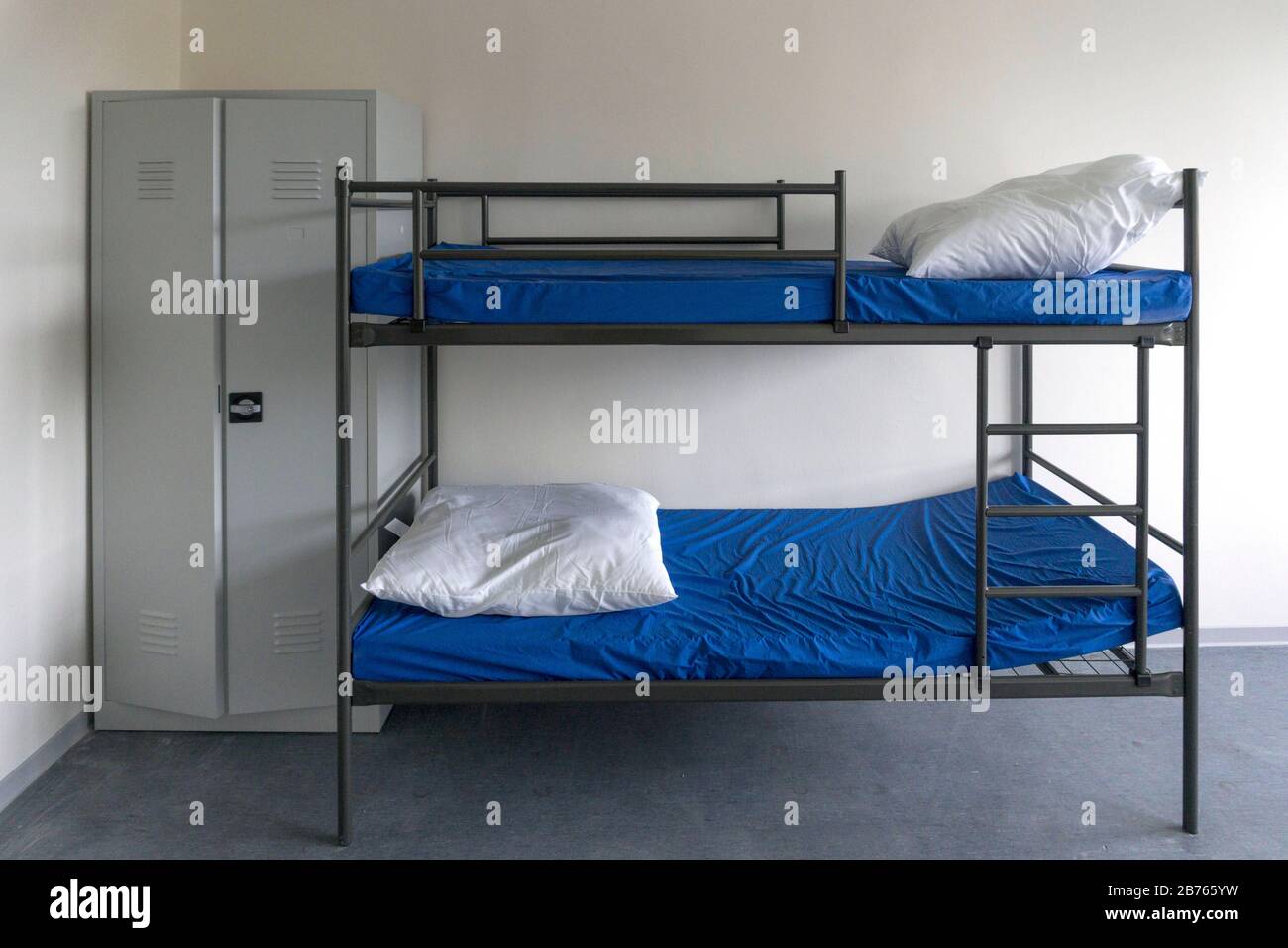 View into a newly furnished room for refugees in a first reception facility for asylum seekers. In the room there is a double bed and a wardrobe, on 05.12.2015 [automated translation] Stock Photo