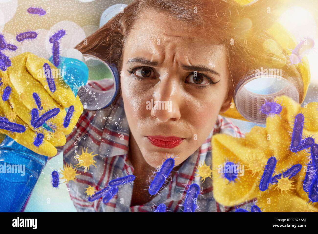 Funny housewife cleans and disinfects to keep germs, viruses and bacteria away. Stock Photo