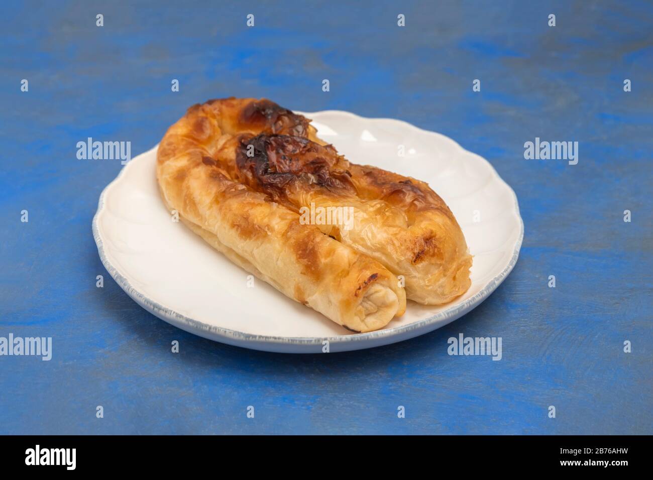 Traditional Bulgarian Cheese Pie Banitsa Made Of Filo Dough On White Plate On Blue Background Stock Photo Alamy