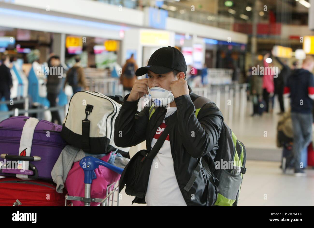A tourist wearing a protective face mask check the flight information