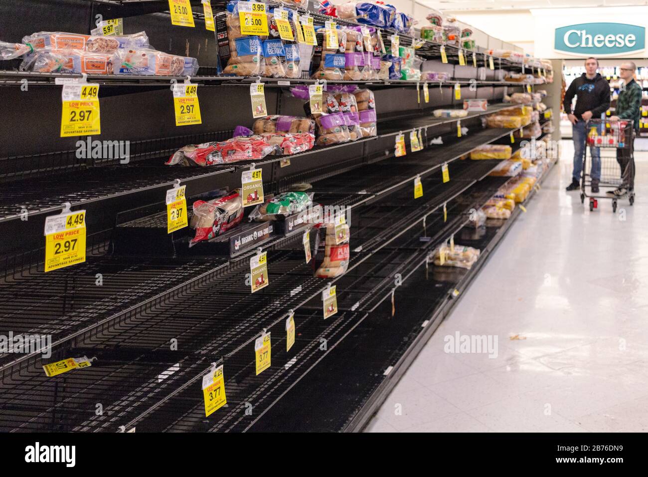 Asheville, USA, 13th Mar 2020. Shoppers survey the bread aisle,during