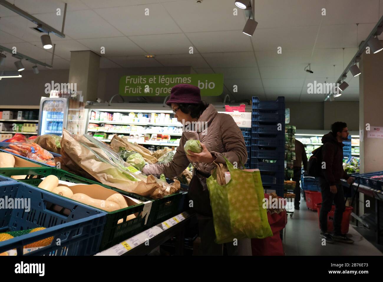 Brussels, Belgium. 13th Mar, 2020. A shopper looks at items, with