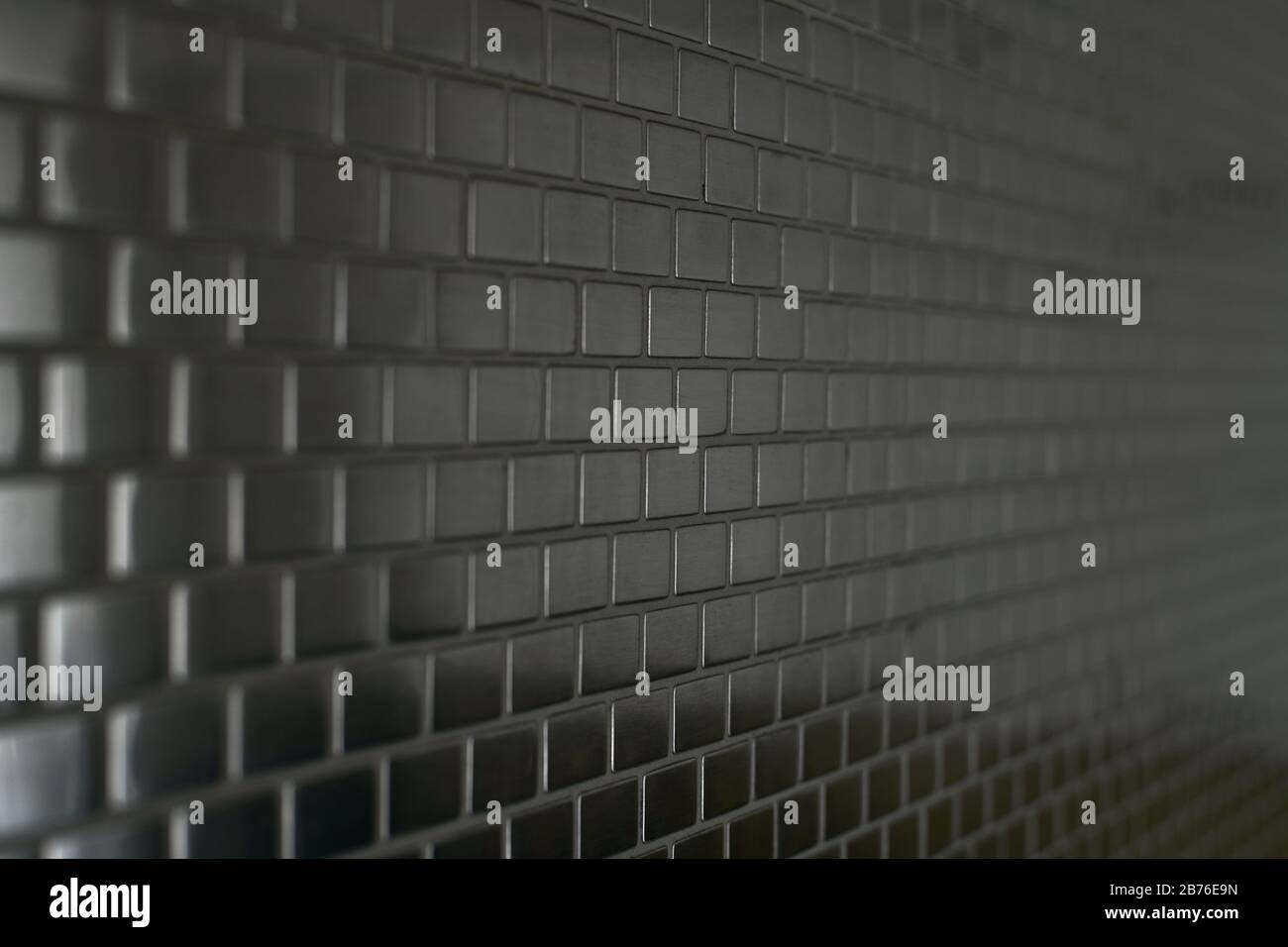 Metal mosaic background with a moving perspective of small bricks. Stock Photo