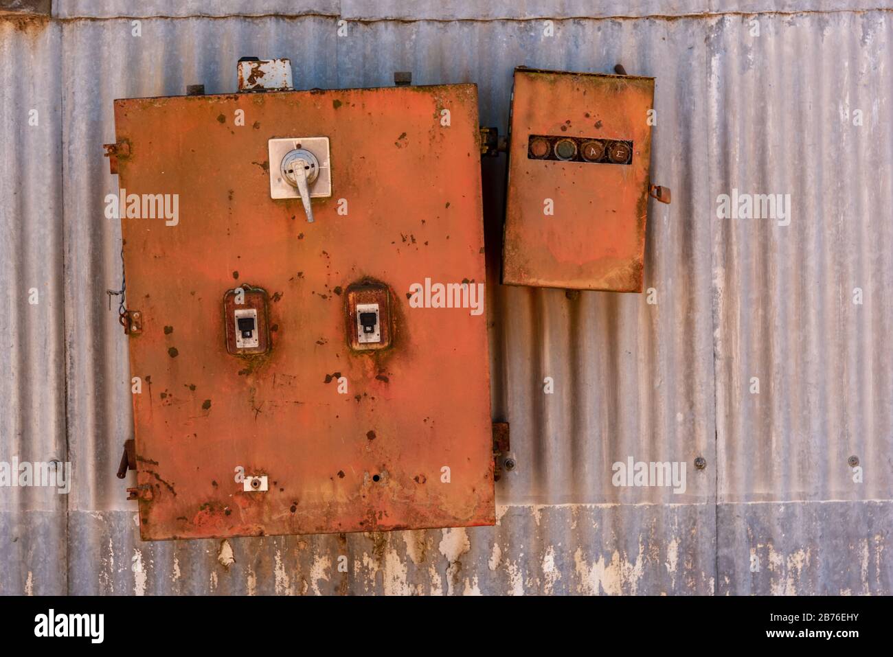 Old rusted iron electricity box with a textured metallic sheet background Stock Photo
