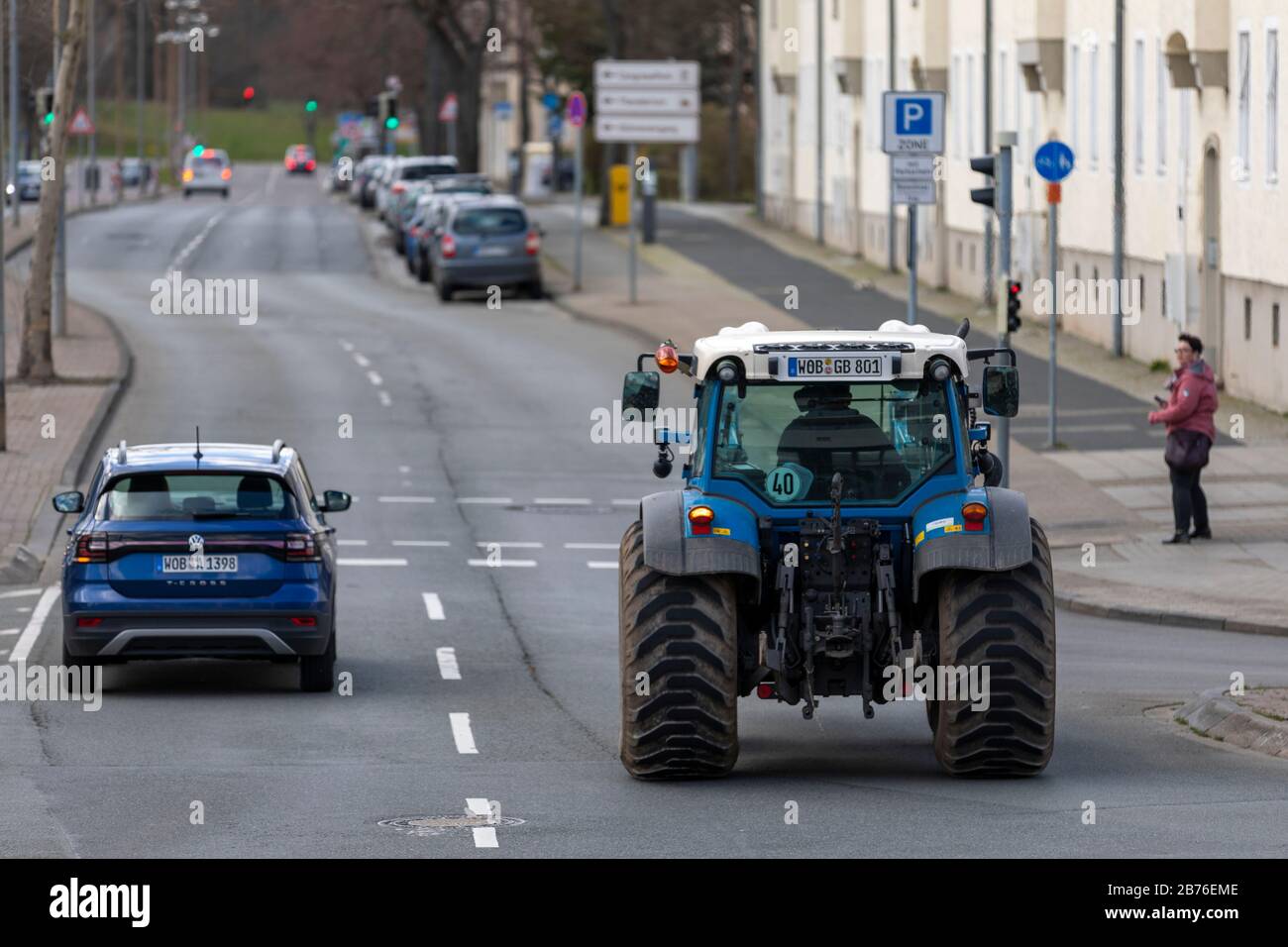 Tractors are part of urban traffic in Wolfsburg Germany. Volkswagen cars are more common because car plant is located in town. Stock Photo