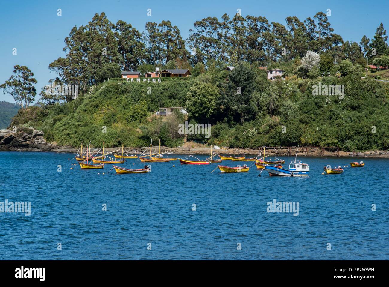 Camping sign on a cliff, Pacific Ocean and a bunch of fisher boats in Los Molinos, Valdivia, Chile Stock Photo