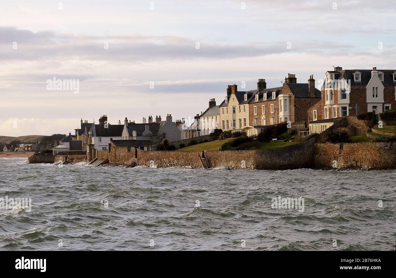 ELIE, SCOTLAND -26 JANUARY 2020: Houses on the shore at The Terrace in winter as a choppy North Sea washes against the sea wall. Stock Photo