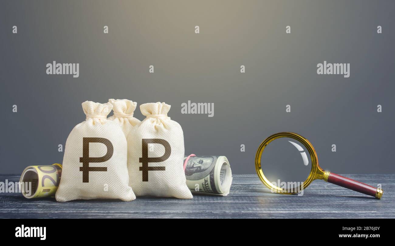 Russian ruble money bags and magnifying glass. Financial monitoring of suspicious cash transactions. Search sources of financing projects. Profitable Stock Photo