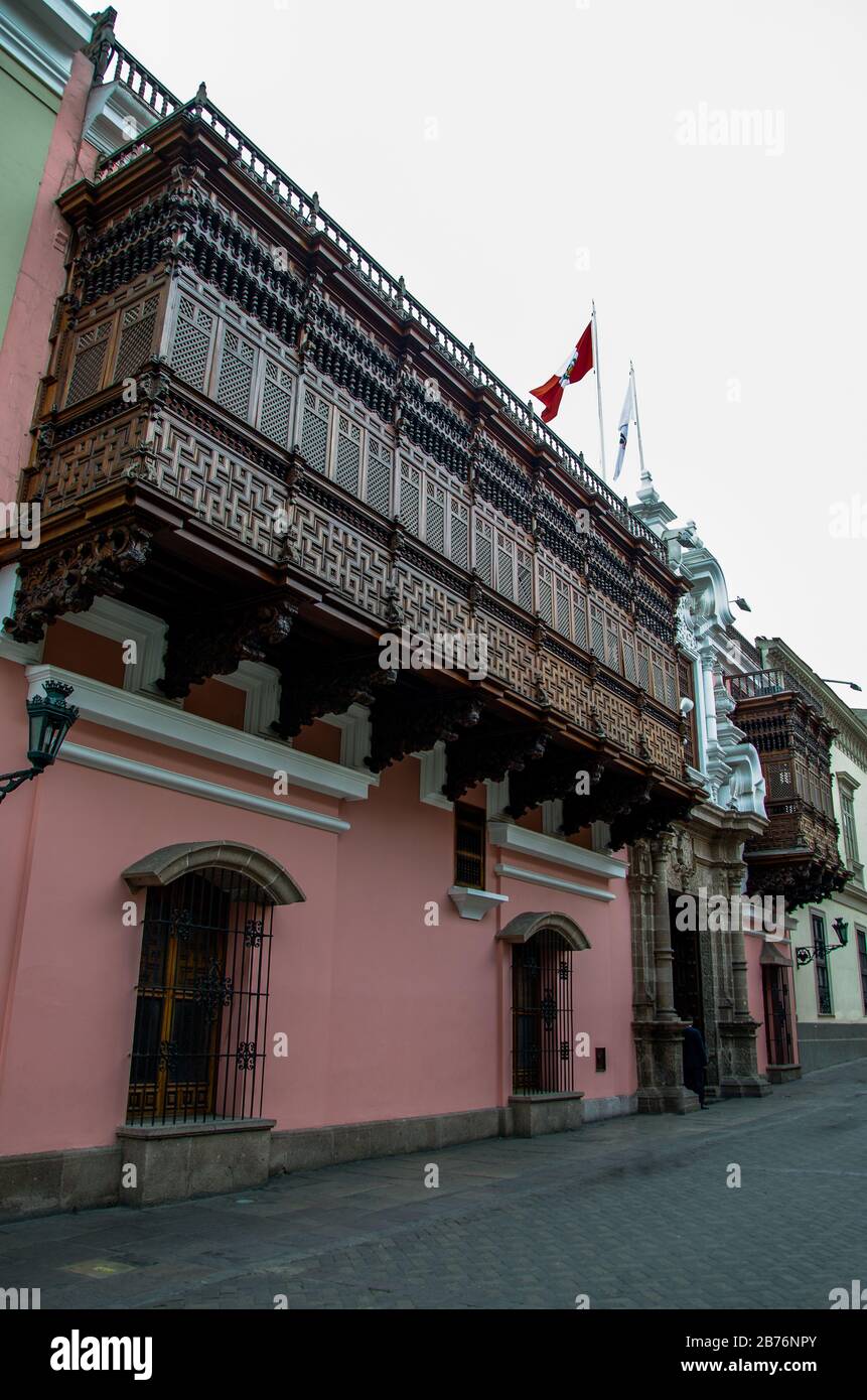 Wrought-wood balconies  of a colonial building on Lima Perú street with peruvian flag on top Stock Photo