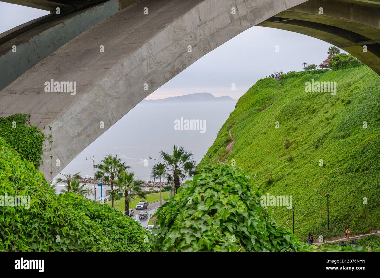 View of the Pacific Ocean trough a bridge with grass in Lima, Peru Stock Photo