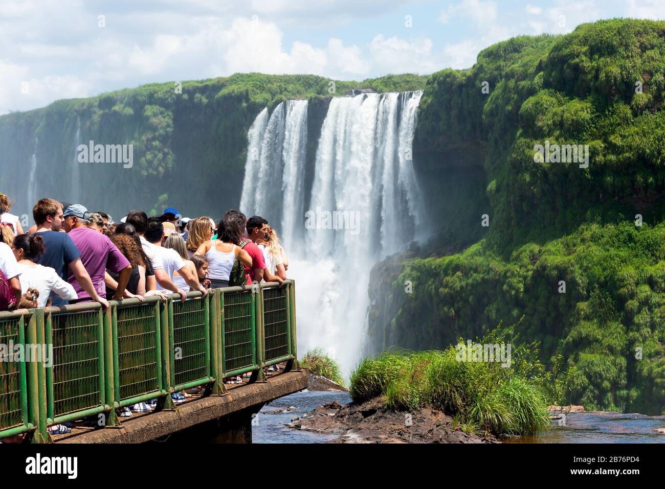 Crowd of tourists at Iguassu National Park (Cataratas do Iguaçu). Over tourism during holidays and vacations. Waterfalls out of focus as background. Stock Photo