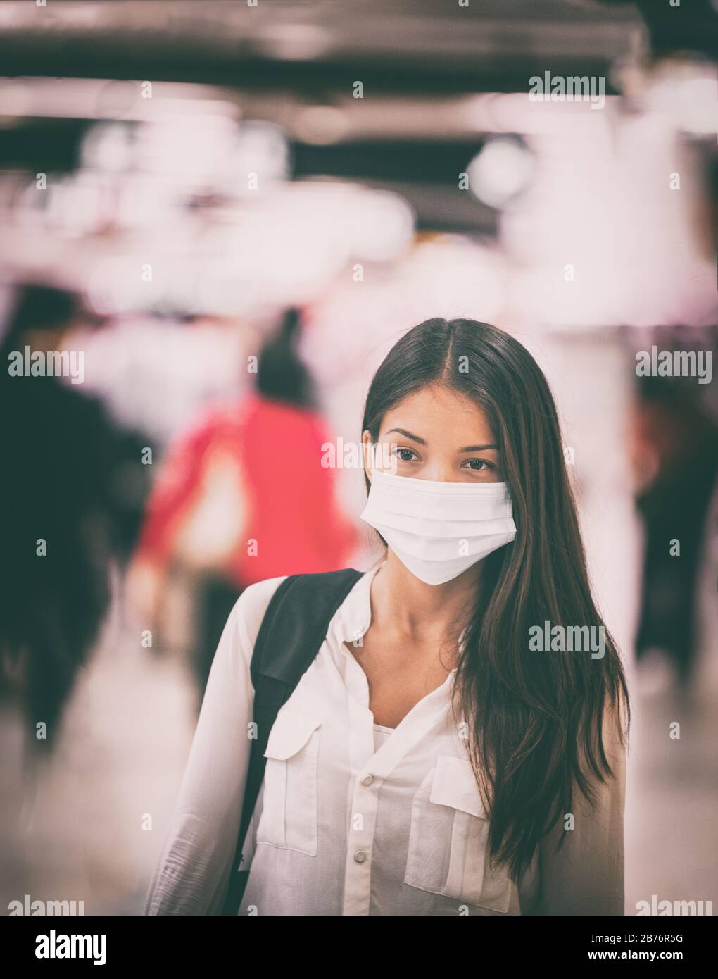 Coronavirus travel Asian woman wearing surgical face mask for virus transmission spreading prevention. Chinese girl on commute in airport flight crowded train station or public space. Stock Photo
