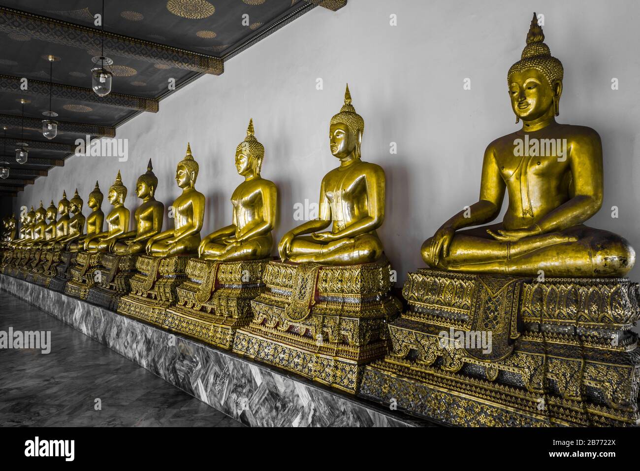 Row of golden buddhist statues in a temple in Bangkok, Thailand. Royalty free stock photo. Stock Photo