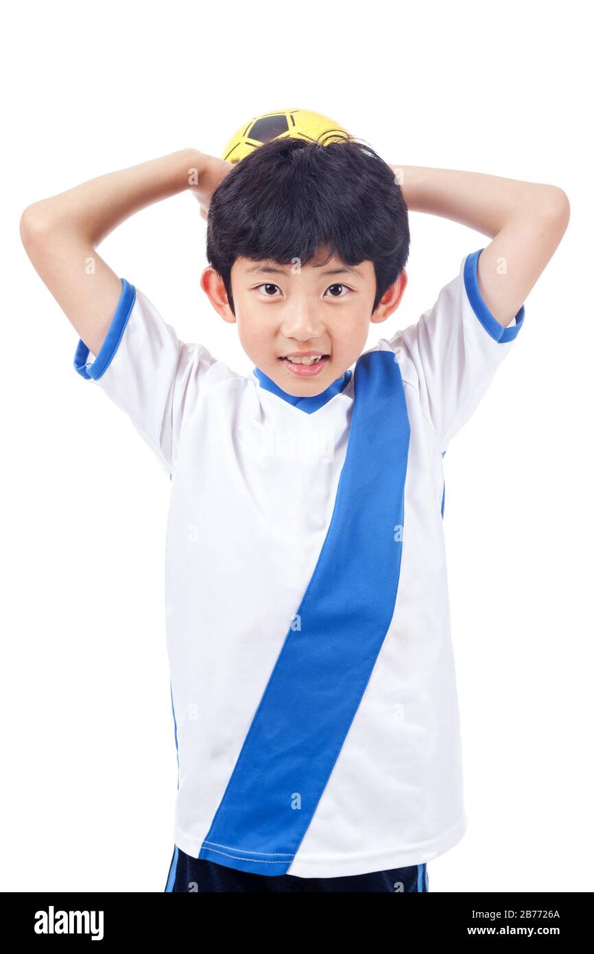 Cheerful young Asian boy holds soccer ball isolated on white background. Stock Photo