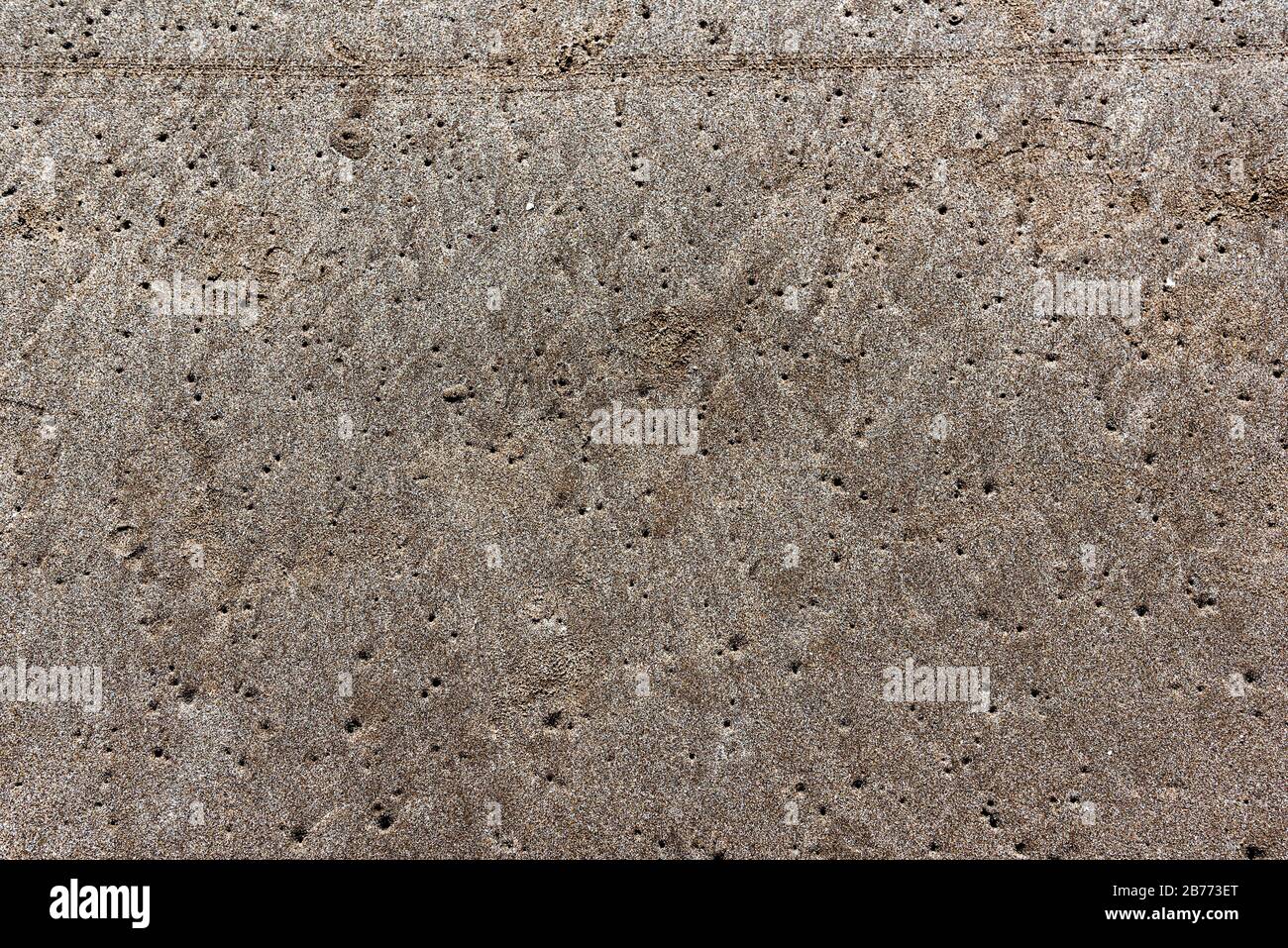 Full frame of sand full of tiny holes made by clams Stock Photo