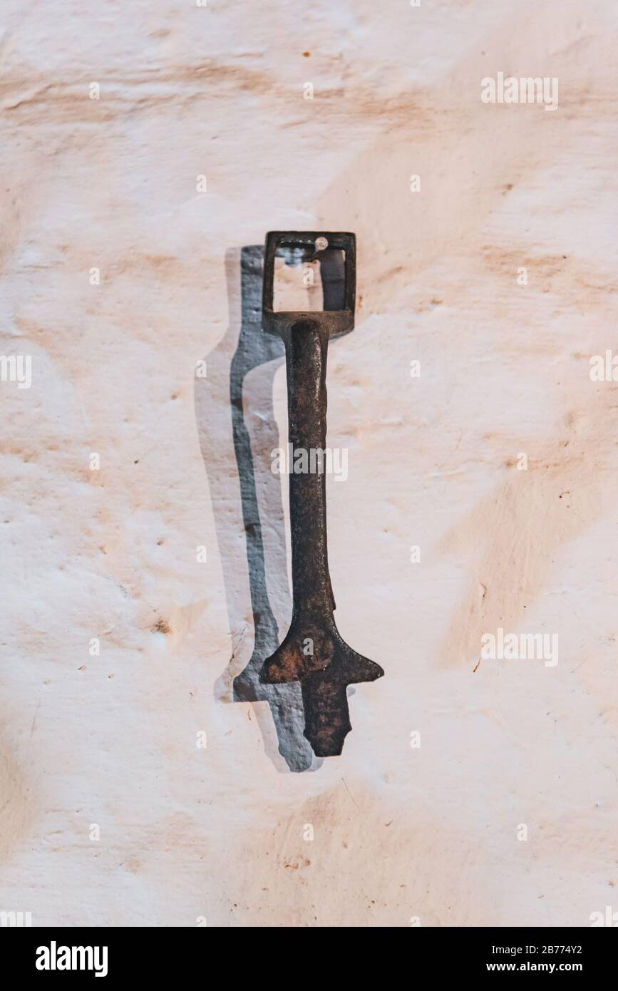 Iron tools hanging on a white wall Stock Photo
