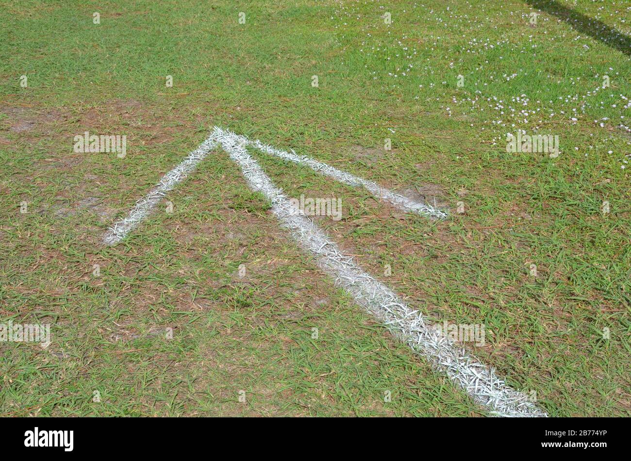 green grass or lawn with painted white arrow or pointer Stock Photo