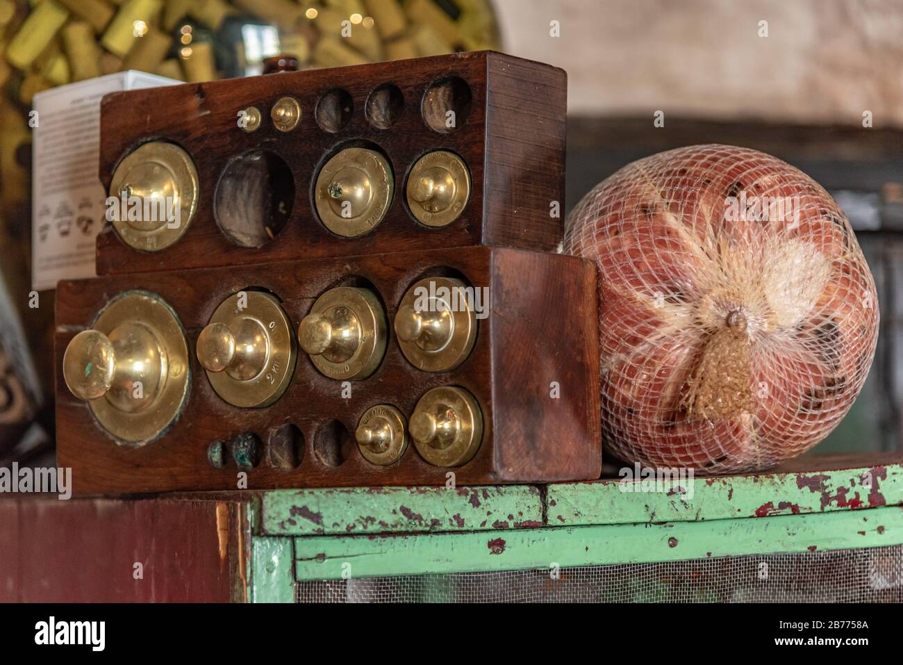 vintage set of weights in a wooden box with a cold ham in a net bag on a side Stock Photo