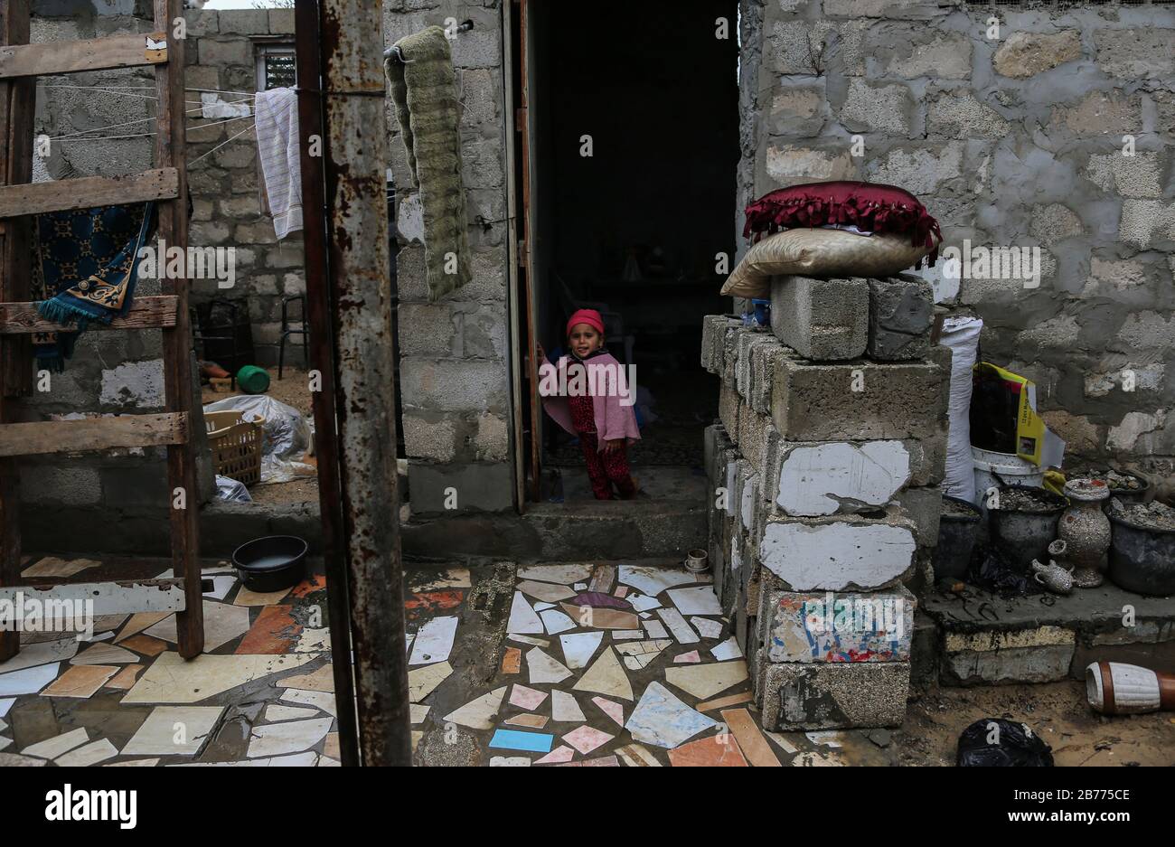 Gaza, Palestine. 13th Mar, 2020. A child stands at her house door during a cold weather wave in the outskirts of the poor neighbourhood of Khan Yunis refugee camp. Credit: SOPA Images Limited/Alamy Live News Stock Photo