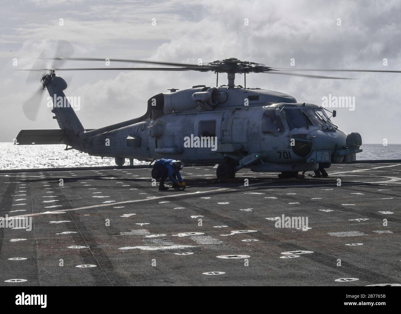 PHILIPPINE SEA (March 13, 2020) Sailors remove chocks and chains from an MH-60R Sea Hawk helicopter assigned to the “Saberhawks” of Helicopter Maritime Strike Squadron (HSM) 77 to the flight deck on Whidbey Island-class dock landing ship USS Germantown (LSD 42) during flight operations. Germantown, part of America Expeditionary Strike Group, 31st Marine Expeditionary Unit team, is operating in the U.S. 7th Fleet area of operations to enhance interoperability with allies and partners and serves as a ready response force to defend peace and stability in the Indo-Pacific region. (U.S. Navy photo Stock Photo