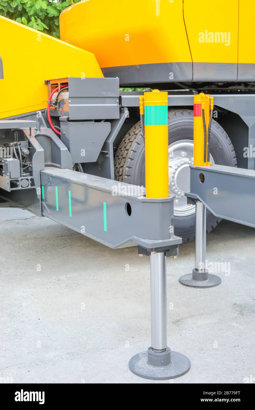 Hydraulic crane leg supports on concrete floor Stock Photo