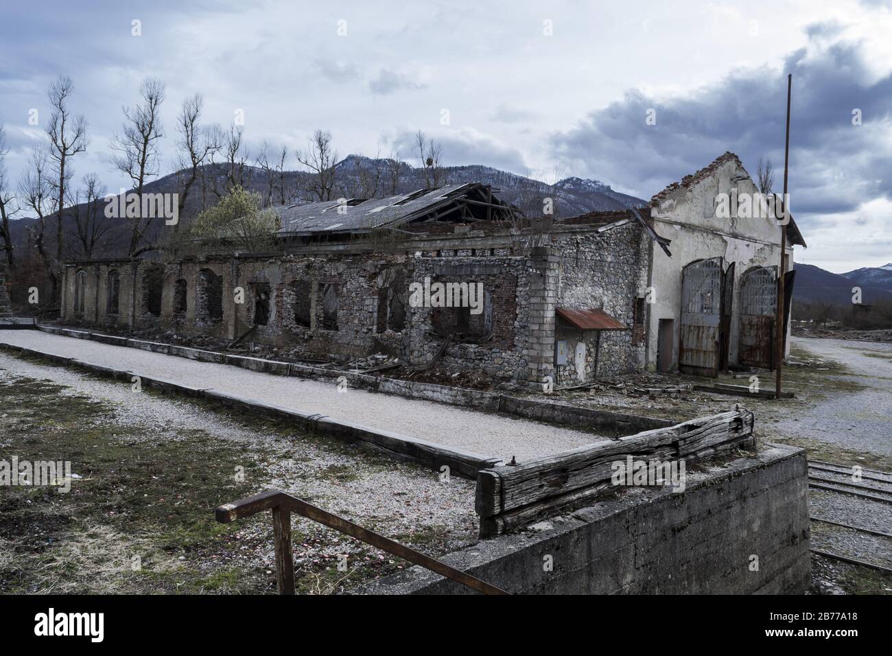 Abandoned building with weathered walls and doors under a cloudy sky ...