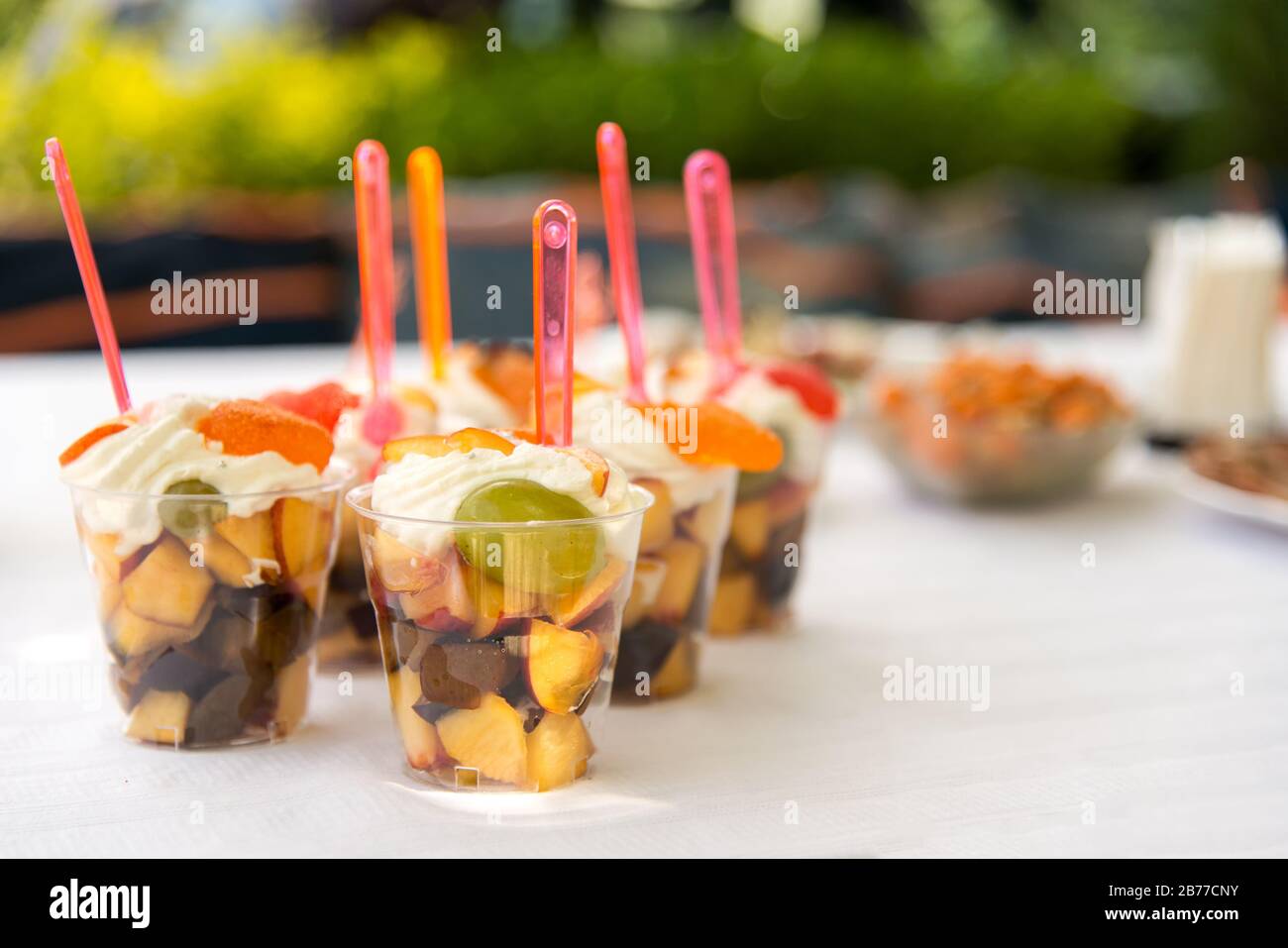 Catering for party. Close up of appetizers with peaches, plums, grapes and  cream in short glasses on white table Stock Photo - Alamy