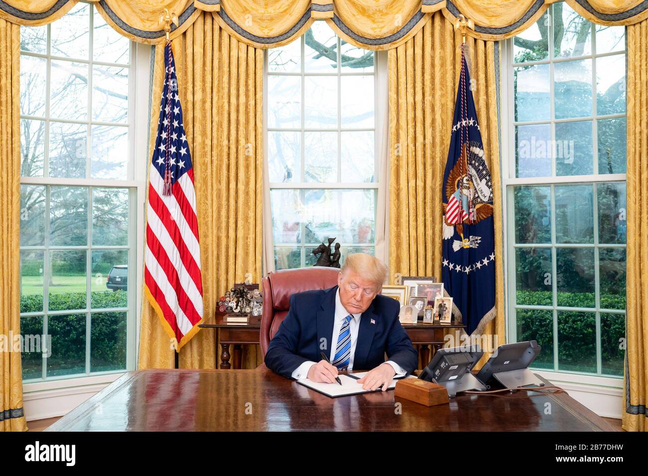 Washington, United States Of America. 11th Mar, 2020. President Donald J. Trump signs a Presidential Memorandum for the Secretary of Health and Human Services and the Secretary of Labor on Making General Use Respirators Available Wednesday, March 11, 2020, in the Oval Office of the White House. People: President Donald Trump Credit: Storms Media Group/Alamy Live News Stock Photo