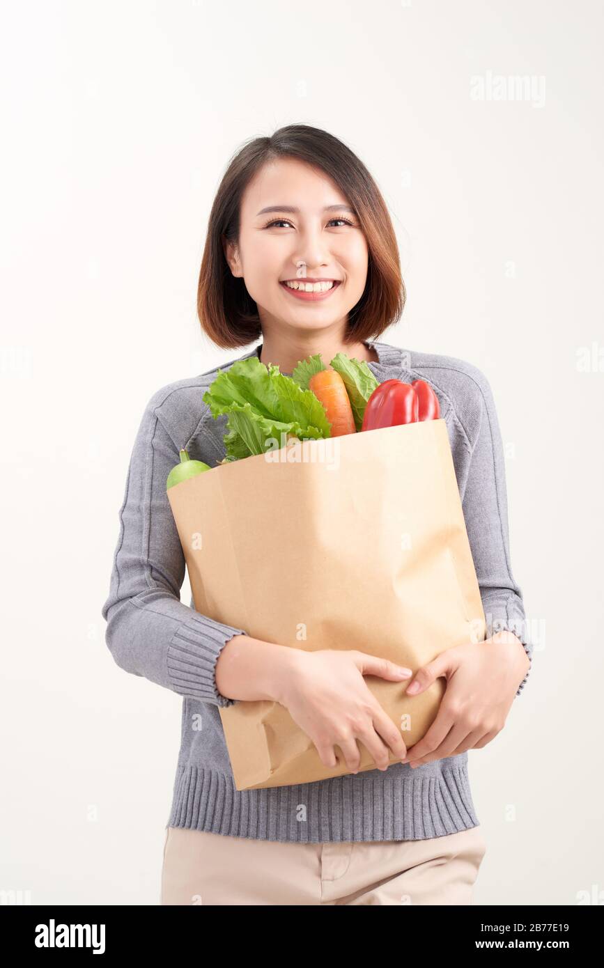 Woman holding grocery shopping bag on white background Stock Photo Alamy