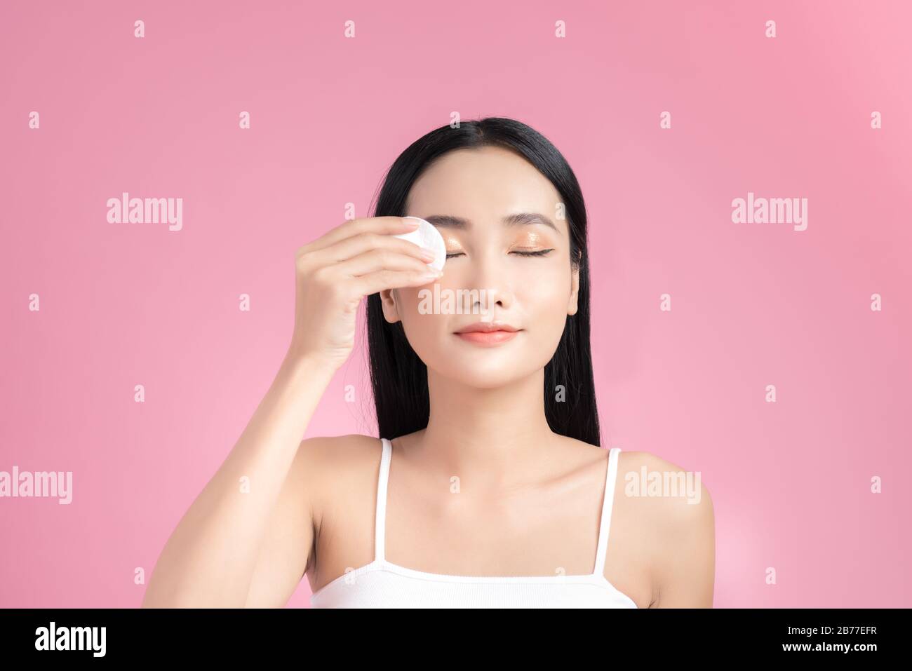 Girl remove makeup. Woman hand with pad. Skin clean with cotton Stock