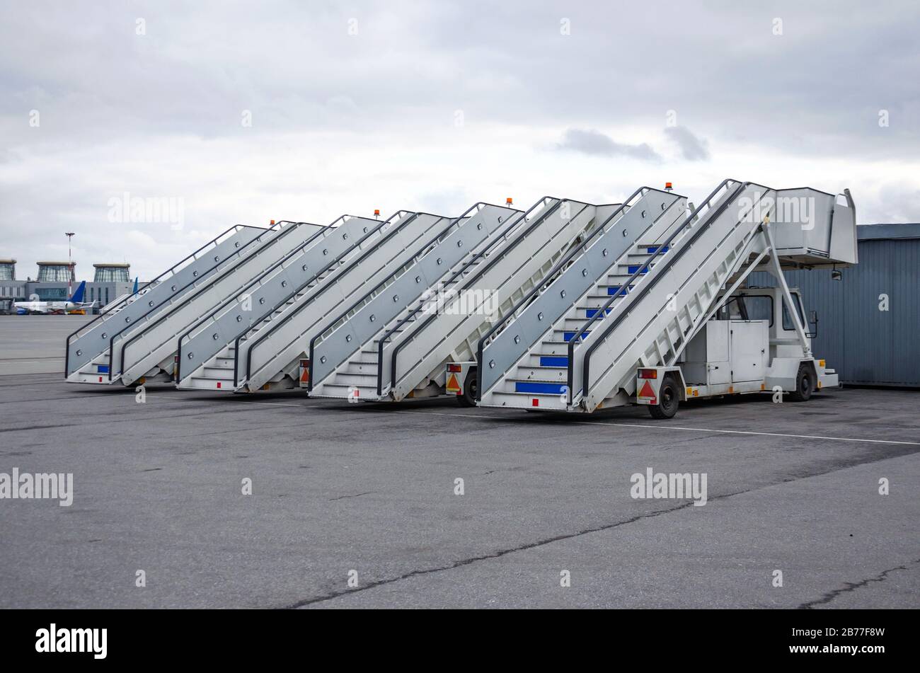 A row of gangways for boarding and alighting passengers from an airplane parked at the airport Stock Photo