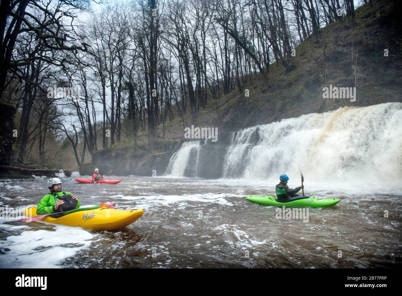 Kayakers rest in the plunge pool after riding the Sgwd y Pannwr falls on the River Mellte near Pontneddfechan in the Brecon Beacons, Wales UK Stock Photo