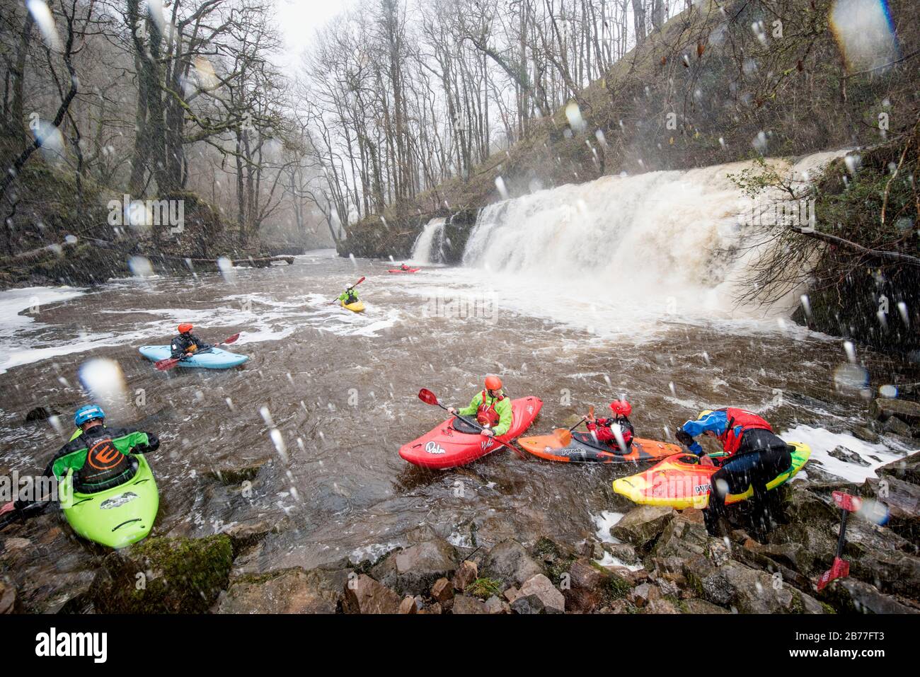 Kayakers rest in the plunge pool after riding the Sgwd y Pannwr falls on the River Mellte near Pontneddfechan in the Brecon Beacons, Wales UK Stock Photo