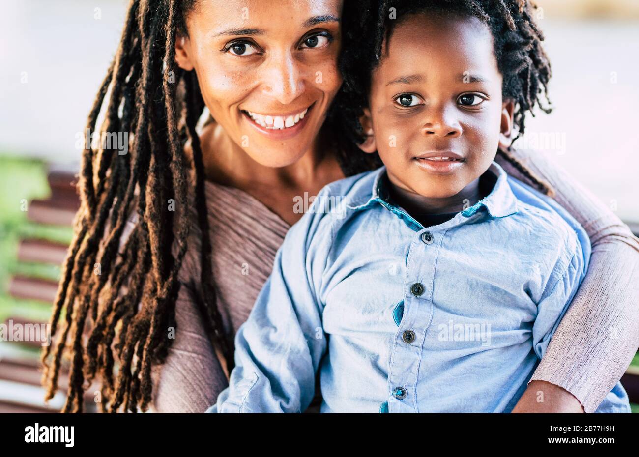 Beautiful diversity alternative family of black african people - mother and son smile in a portrait - trendy dreadlocks dredd hair to adult and childr Stock Photo