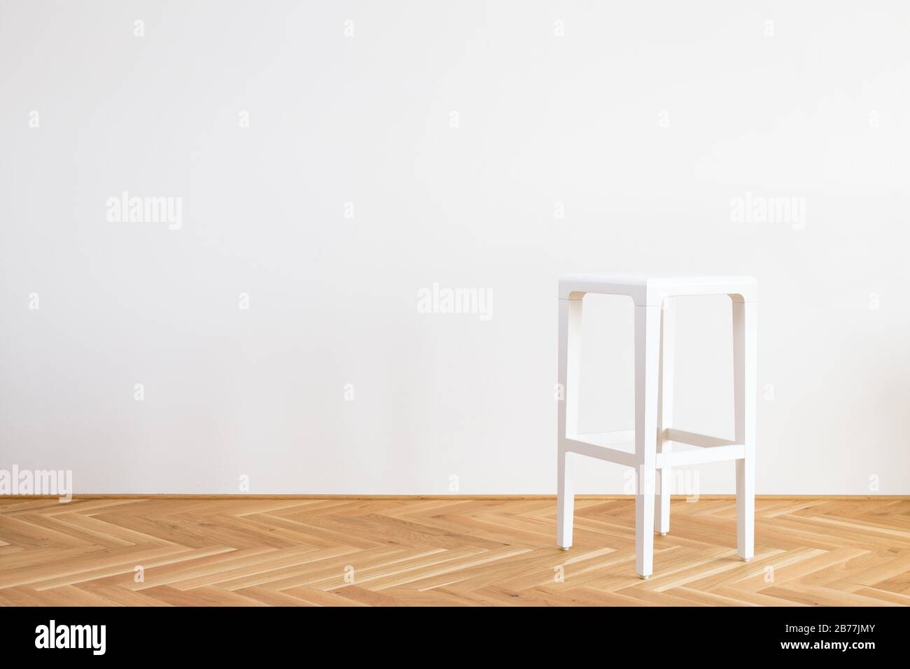 modern simplistic white chair on a wooden flor in front of white background Stock Photo