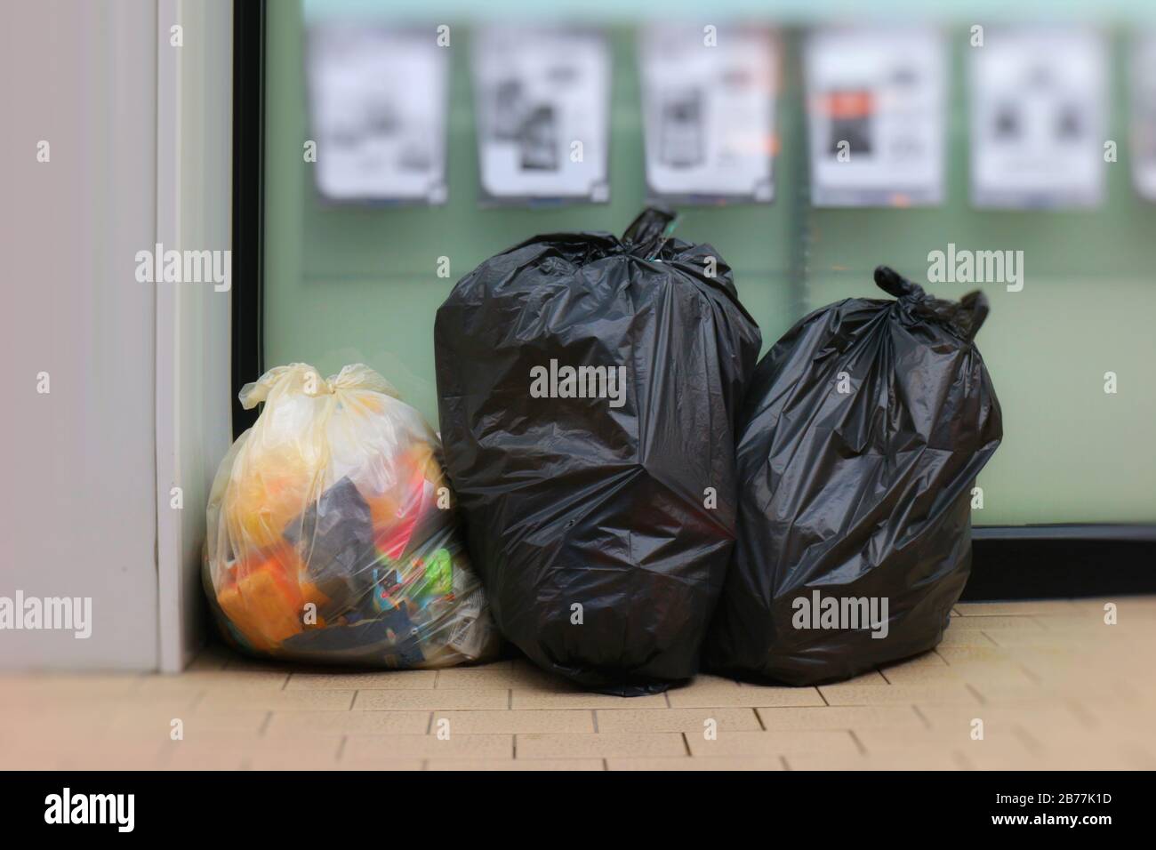 Three Trash Bags, Garbage bag black placed front convenience store, Bin