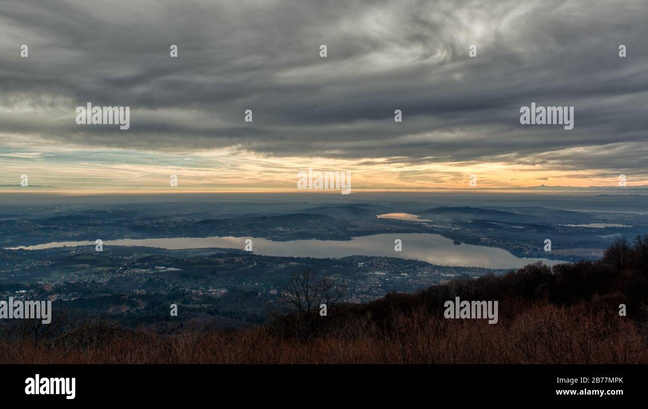 Cloudy sundown over the lake of Varese with mountains at the horizon Stock Photo