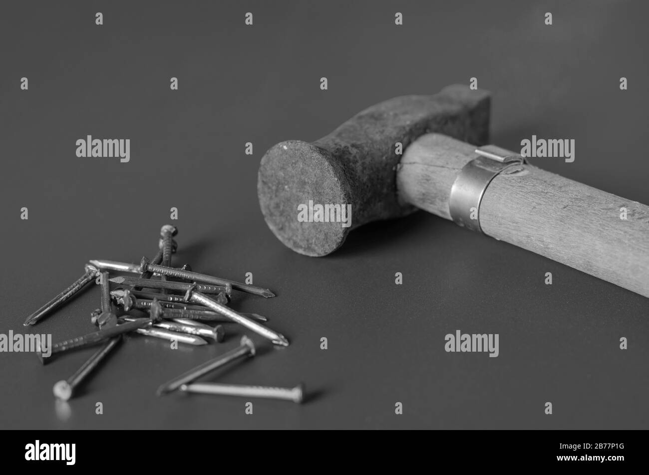 Old hammer and a set of nails on a grey background. Little rusty hammer