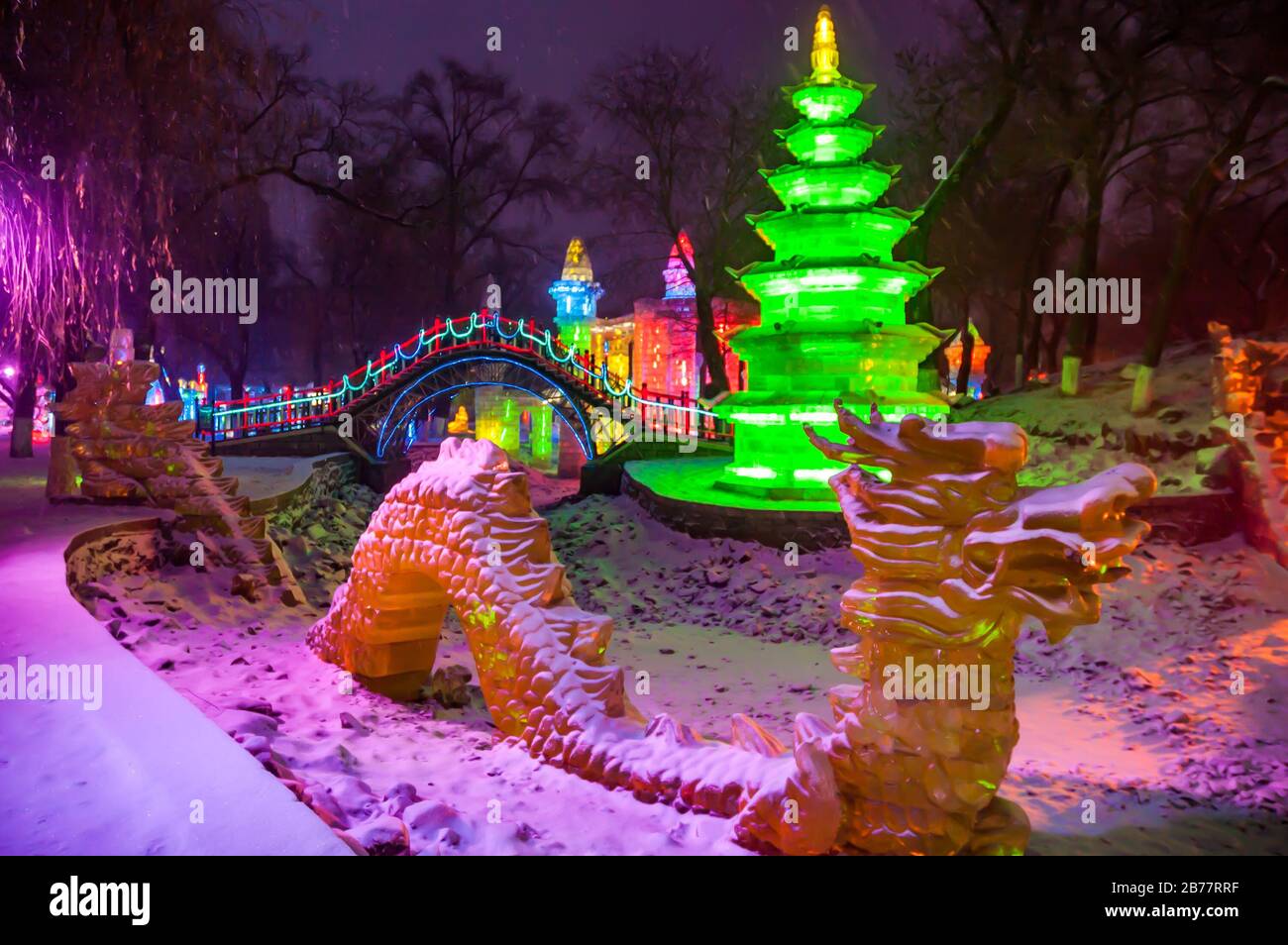 Ice sculptures illuminated in the early evening in Harbin’s Zhaolin Park. Stock Photo