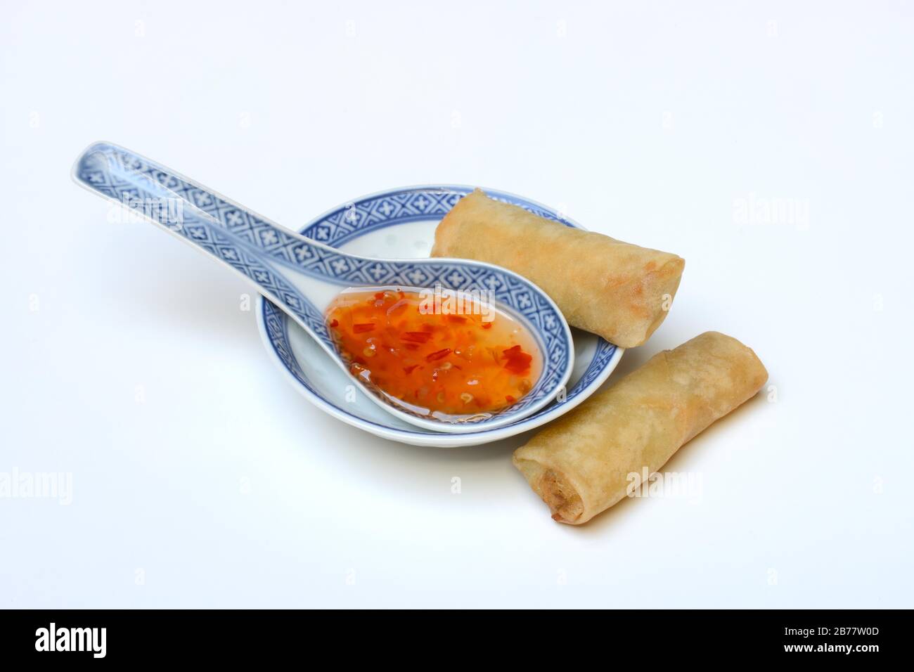 Chilli sauce in Asian spoon and mini spring rolls, Germany Stock Photo