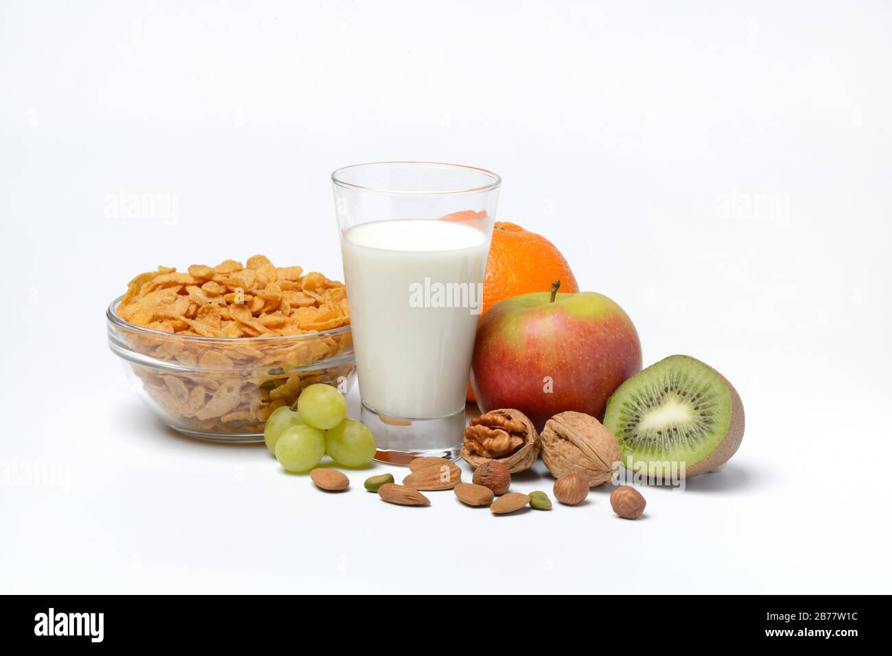 A glass of milk, bowl with cornflakes, fruits and nuts, Germany Stock