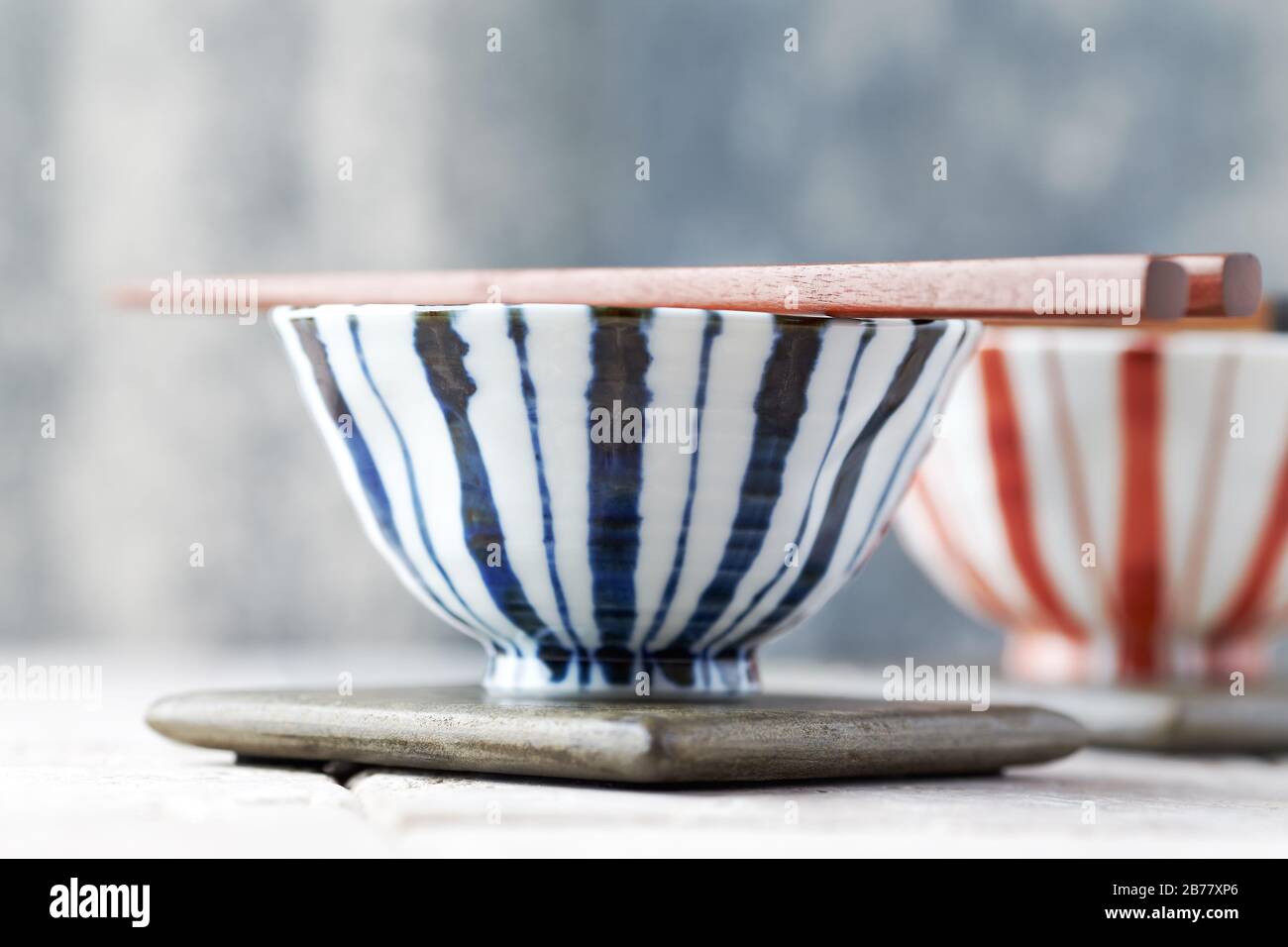 Wooden Chopsticks and ceramic Bowls on bright background Stock Photo