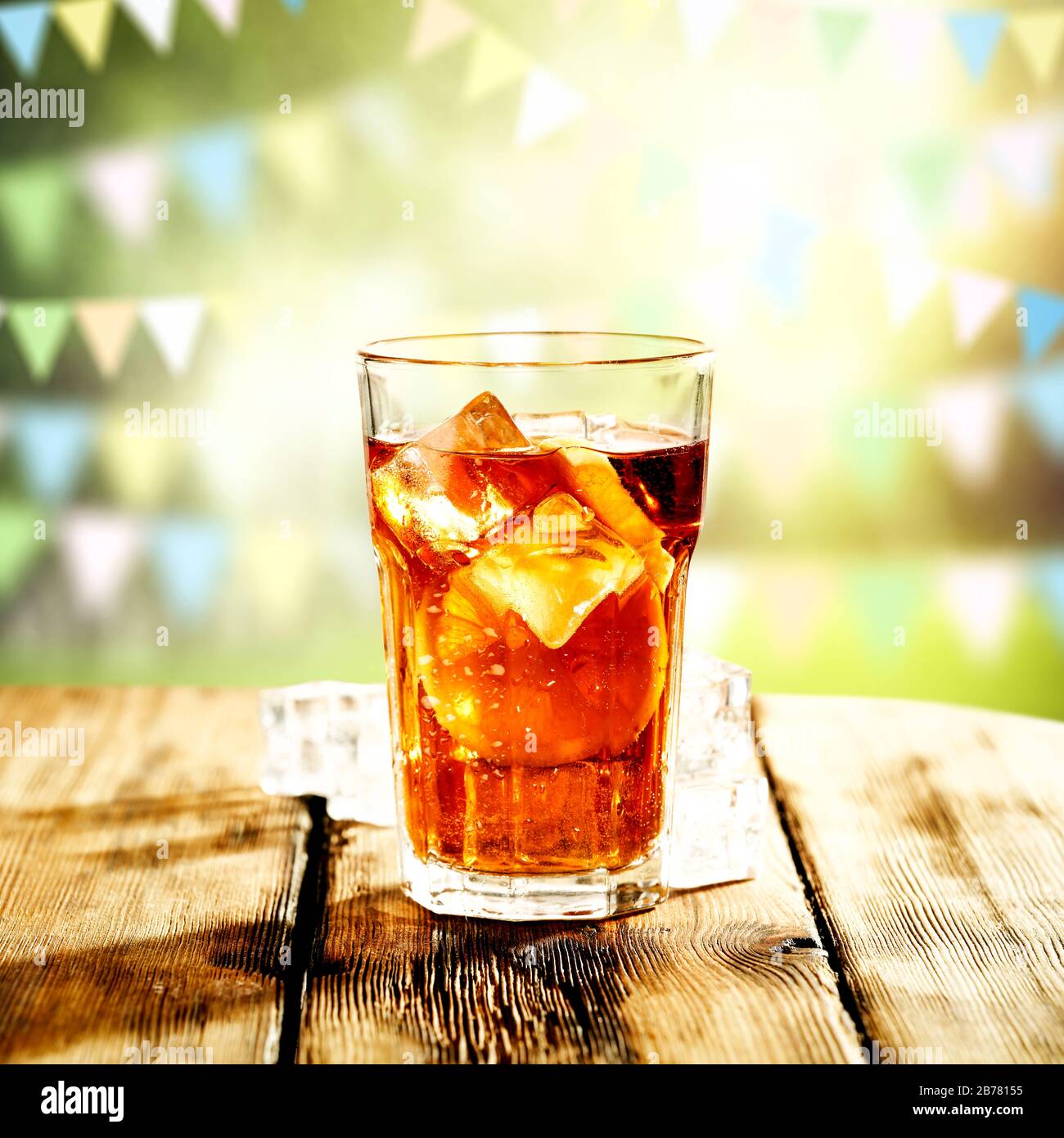 https://c8.alamy.com/comp/2B78155/ice-tea-in-a-big-glass-on-wooden-table-with-blurred-spring-outdoor-background-2B78155.jpg