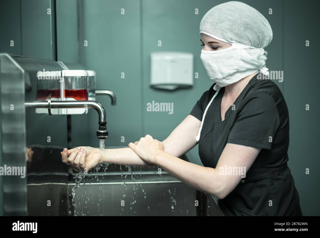 Nurse in protective medical mask washes hands Stock Photo