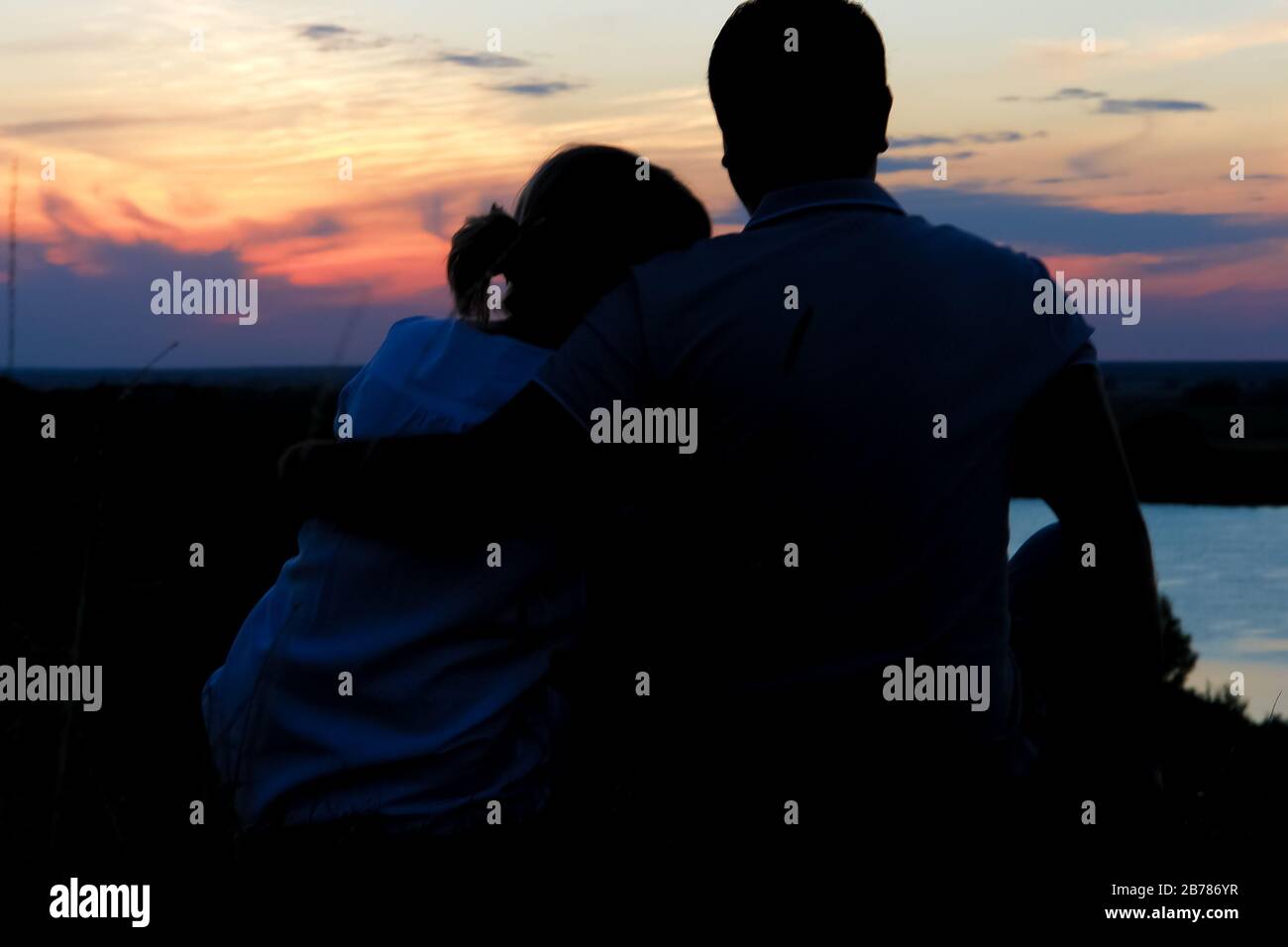Young couple silhouette against sunset sky. Romantic eveningn Stock ...