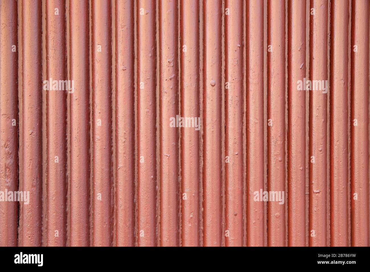 Wavy corrugated metal sheet with vertical bars painted with dark red