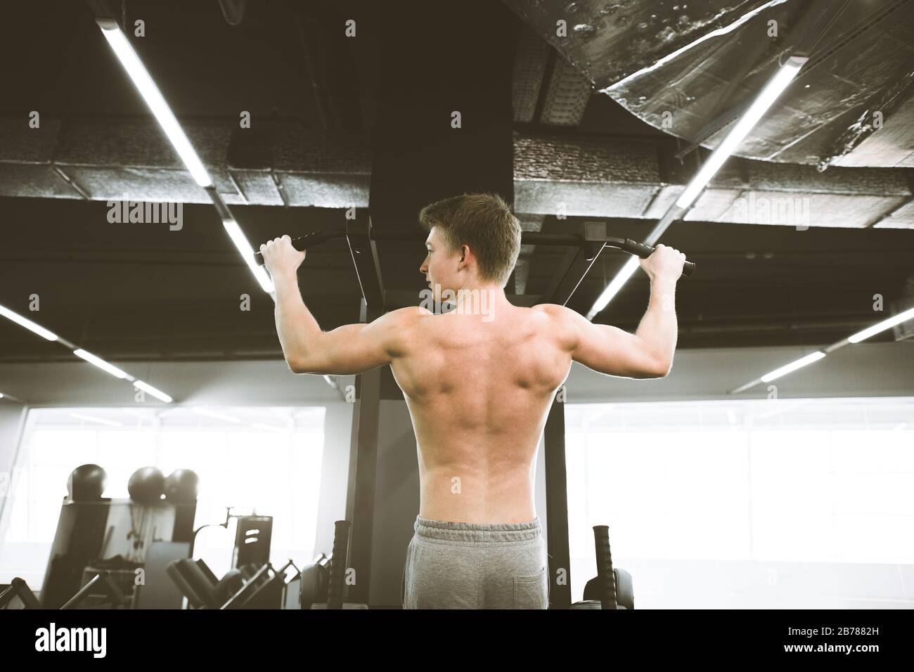 Athlete Muscular Fitness Male Model Pulling Up On Horizontal Bar In A Gym Stock Photo Alamy